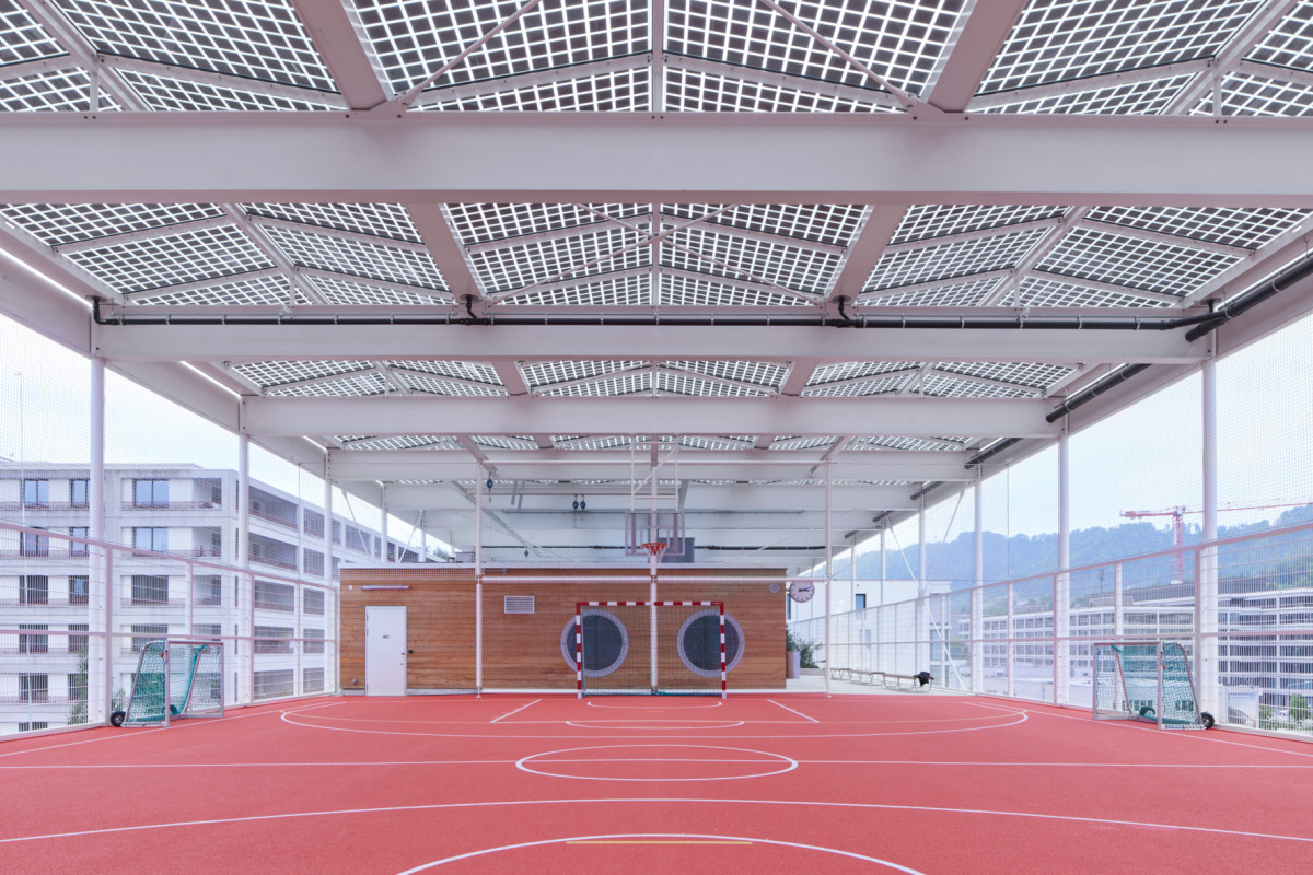 Toiture solaire translucide au damier de cellules de silicium espacées - Schule Allmend, Zurich ZH © Schörghuber